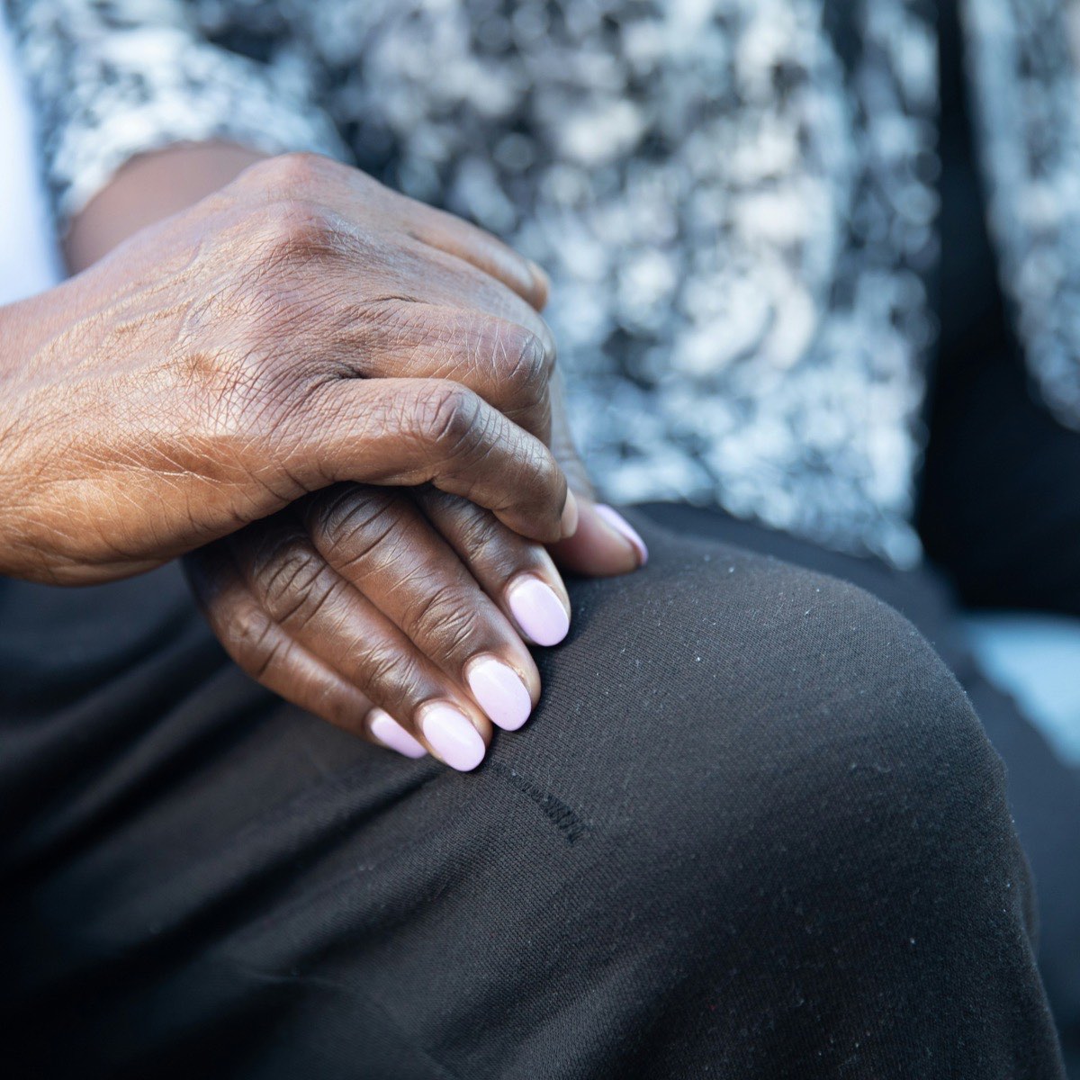 Placeholder: a pair of clasped hands resting on a knee