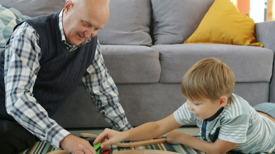 A grandfather playing a game on the floor with a young boy