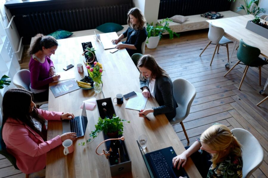 A group of people working on laptops around a shared table