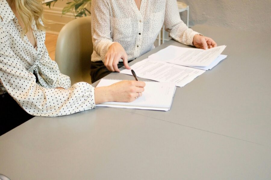 Two people at a table working through paperwork together